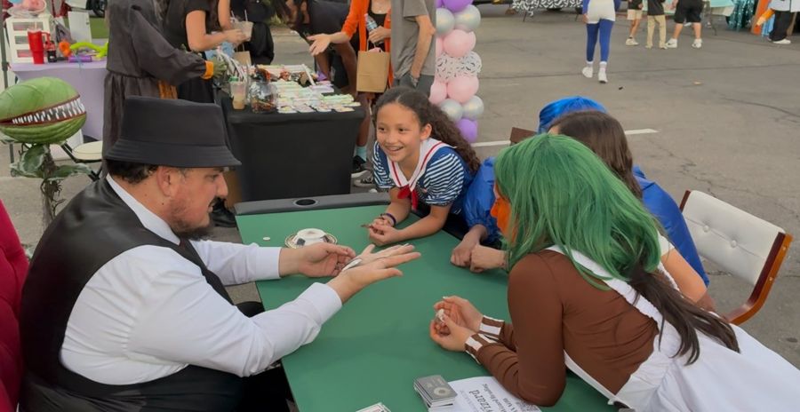 The Wizard at the table with guests leaning in